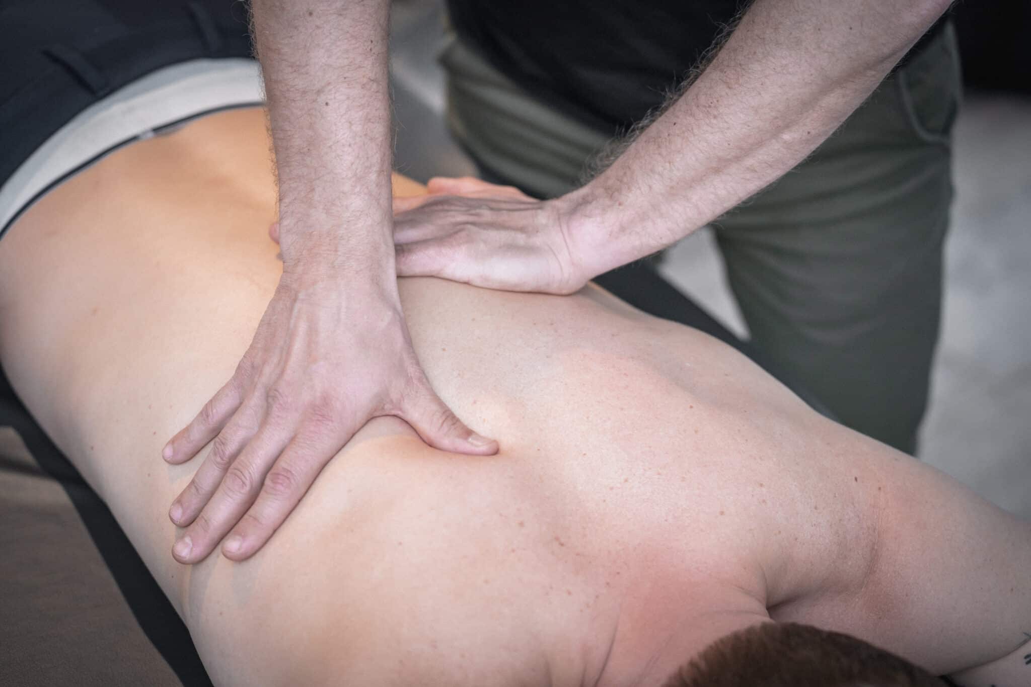 Mand får massage på ryggen, muligvis behandling mod ondt i ryggen hos Minosteopat.