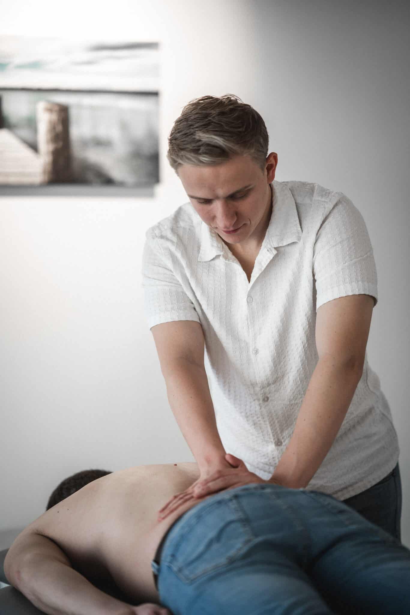 Behandler udfører manuel trykbehandling på patientens lænd for at lindre smerter i lænden og ned i benet.