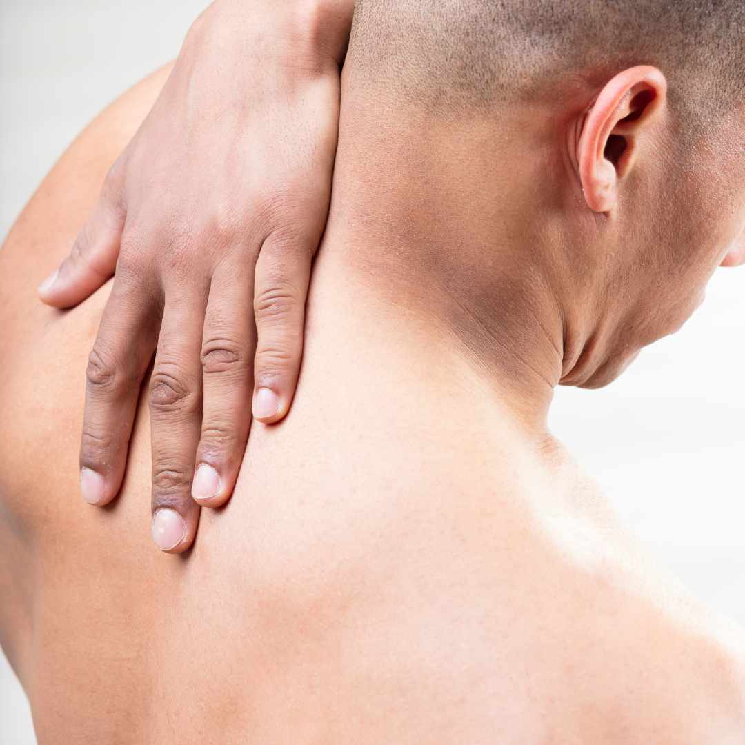 Mand med hånd på nakken oplever spændinger og spørger sig selv: kan myoser masseres væk?