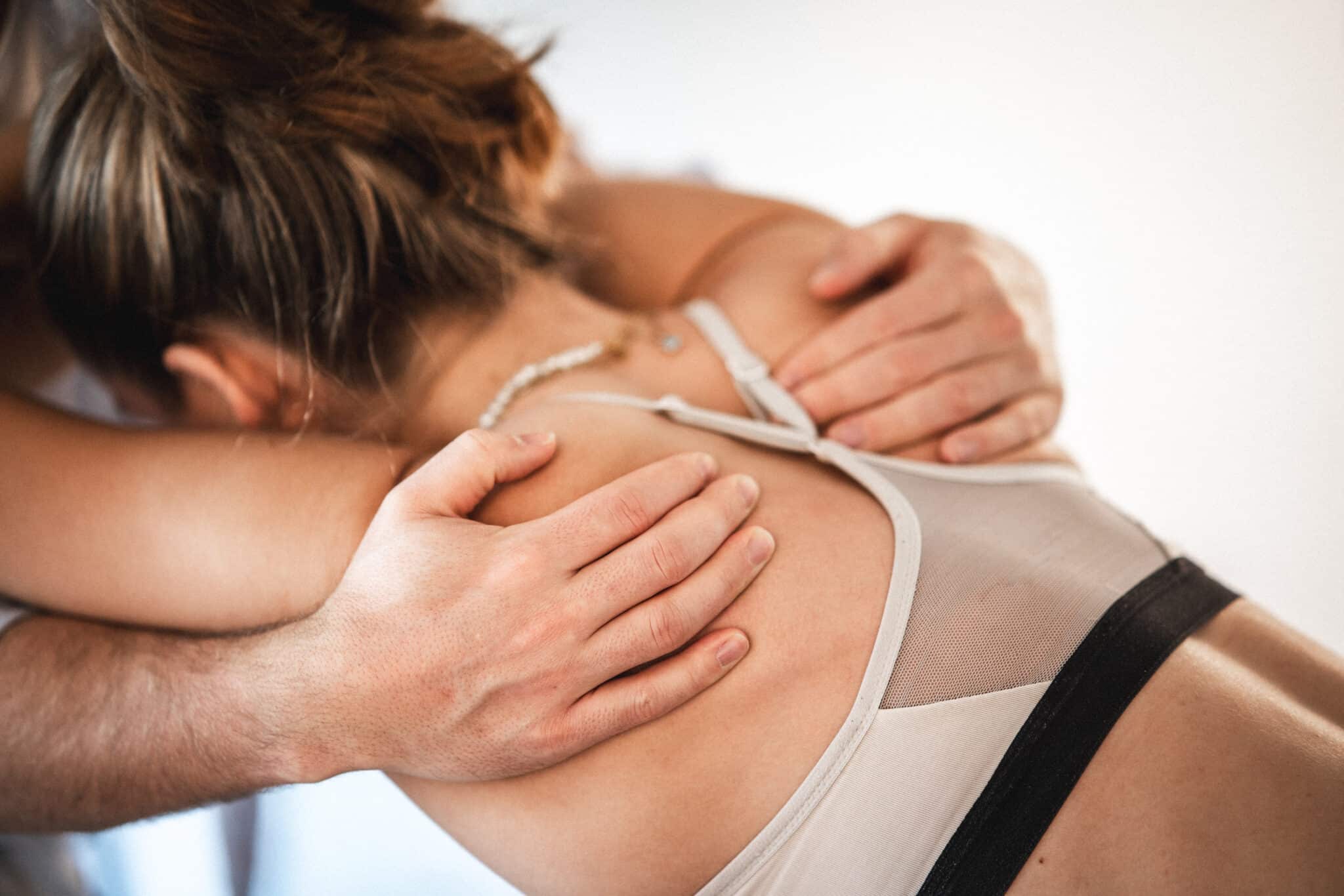 Fysioterapeut arbejder med ryg og skuldre på patient som led i behandling af stive led.