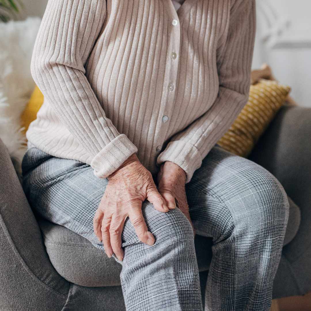 Ældre person holder sig til knæet på grund af smerter i benene.