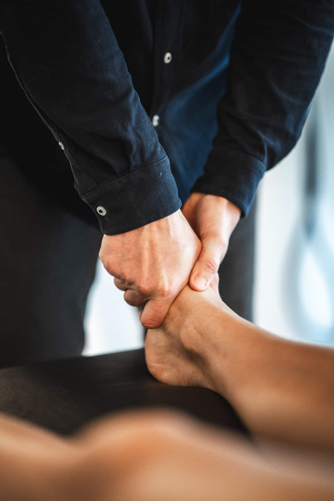 Osteopat udfører manuel behandling af ankel for at øge bevægelighed og afhjælpe stive led.