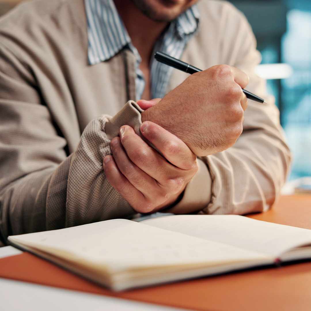 Ældre mand holder om håndled ved smerter forårsaget af seneskedebetændelse.