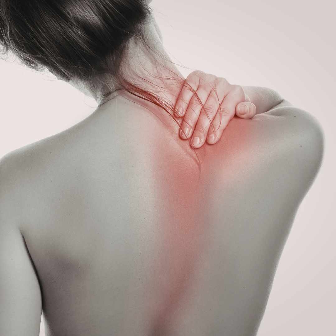 Person tager sig til nakke og øvre ryg ved smerter i skulderblad.