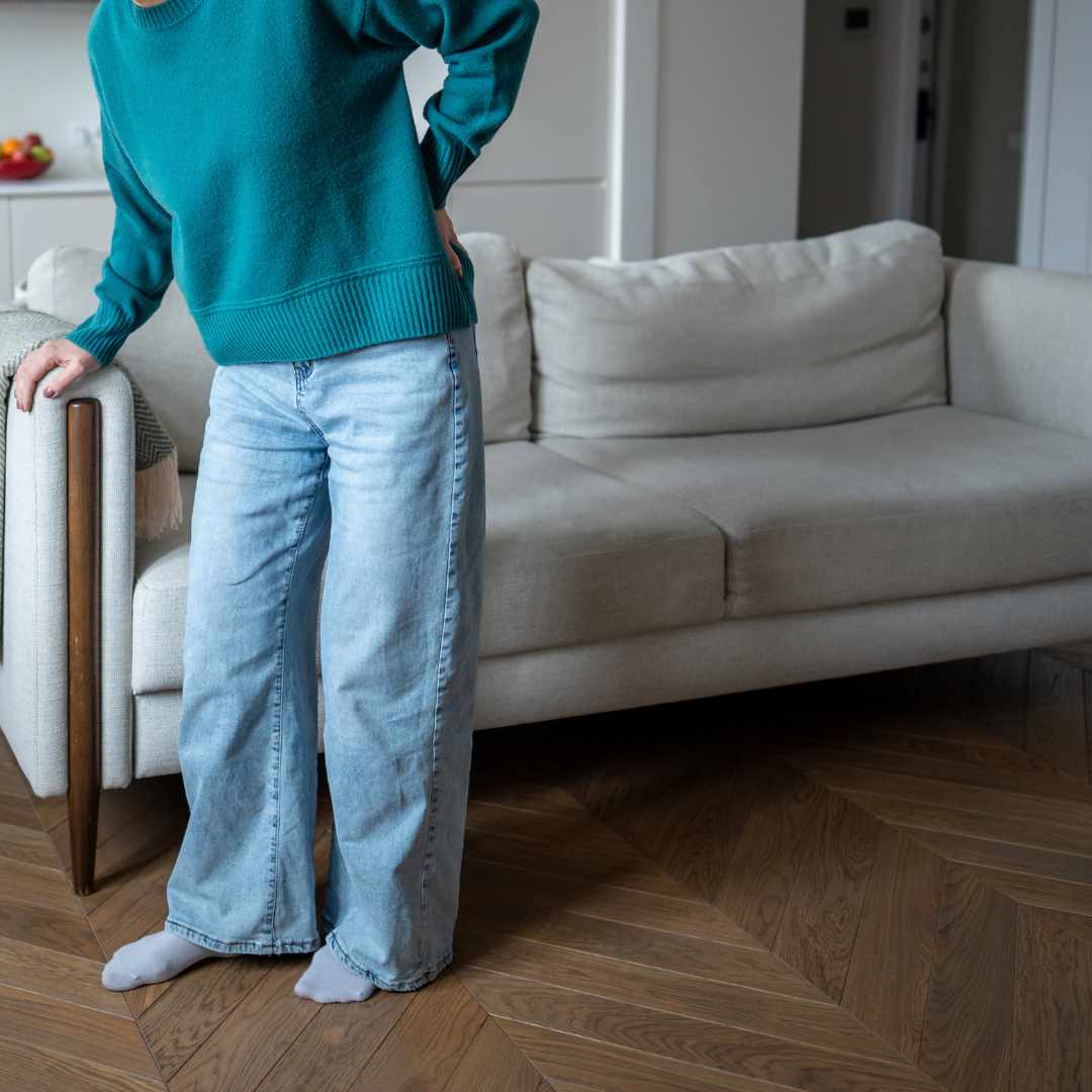 Person står og holder sig på lænden ved iskiassmerter og udstrålende smerte.